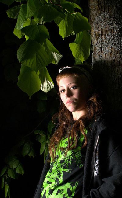 Portrait einer Frau im Dunkeln mit Blätter